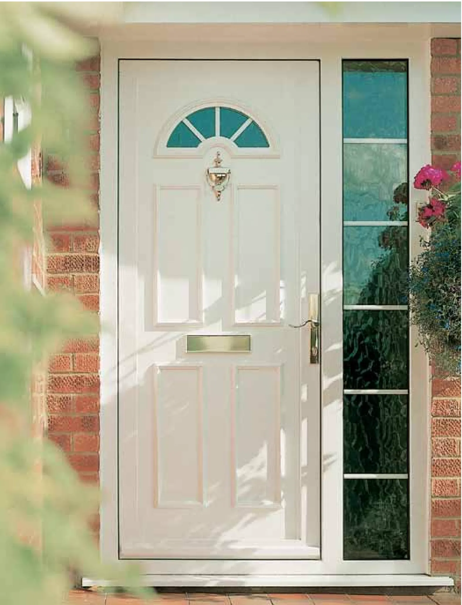 Cream front door with decorative glazing beside a brick wall