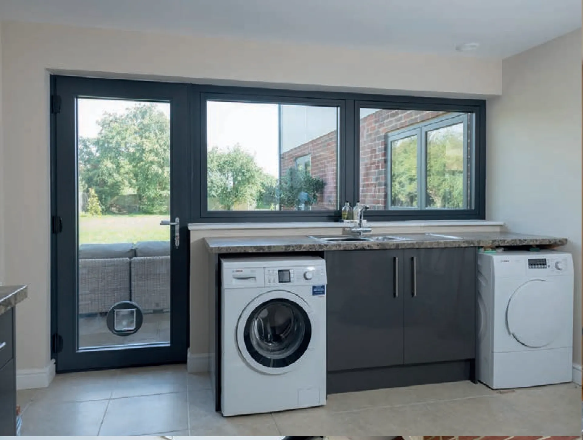 Dark grey windows and a glazed door in a light utility room