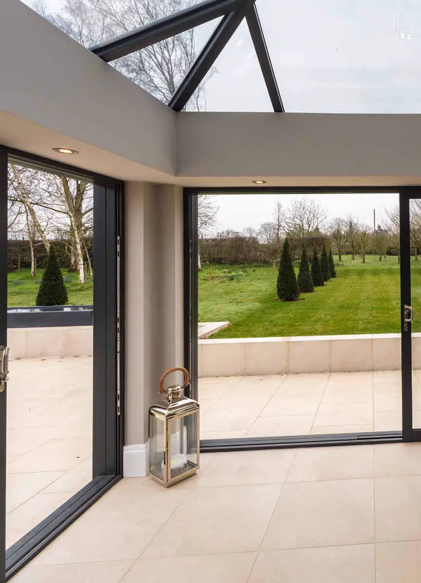Conservatory interior with a glass roof and wide garden-facing doors