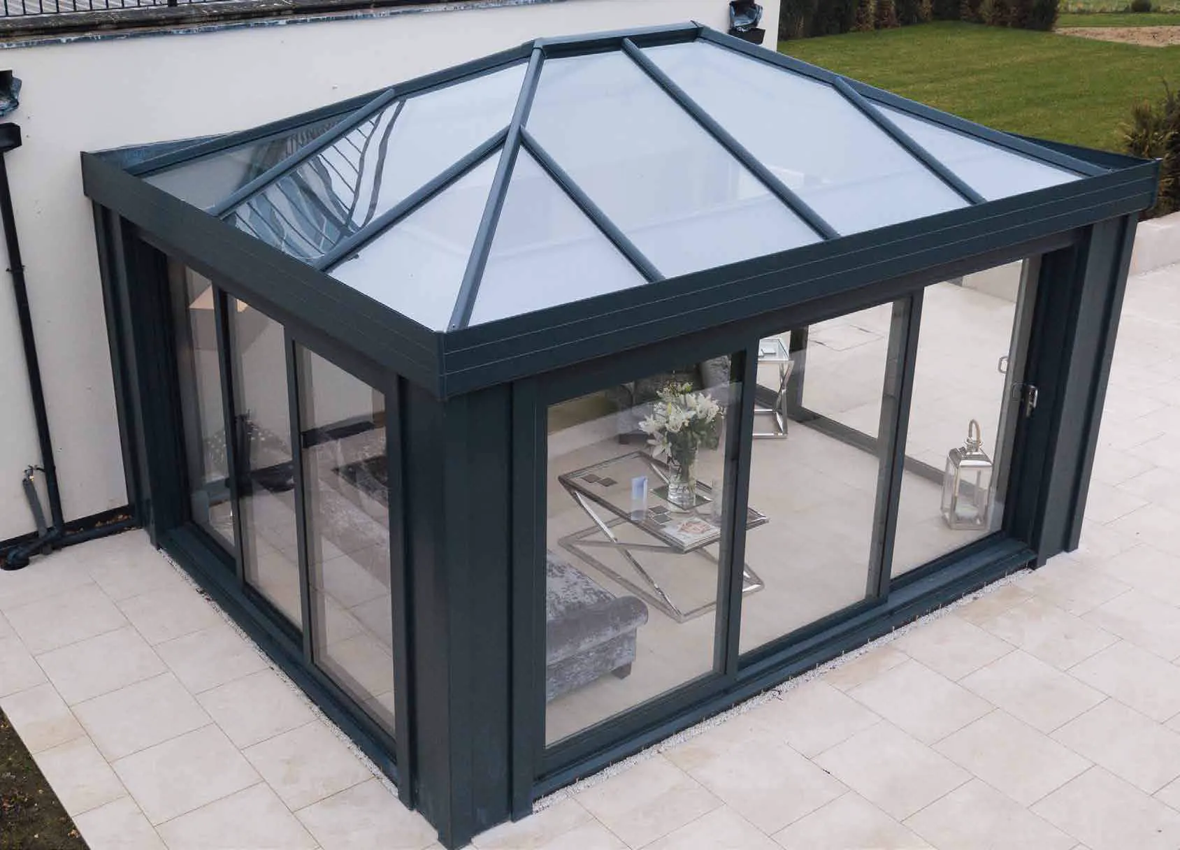 Graphite-coloured conservatory with a glass roof and sliding doors