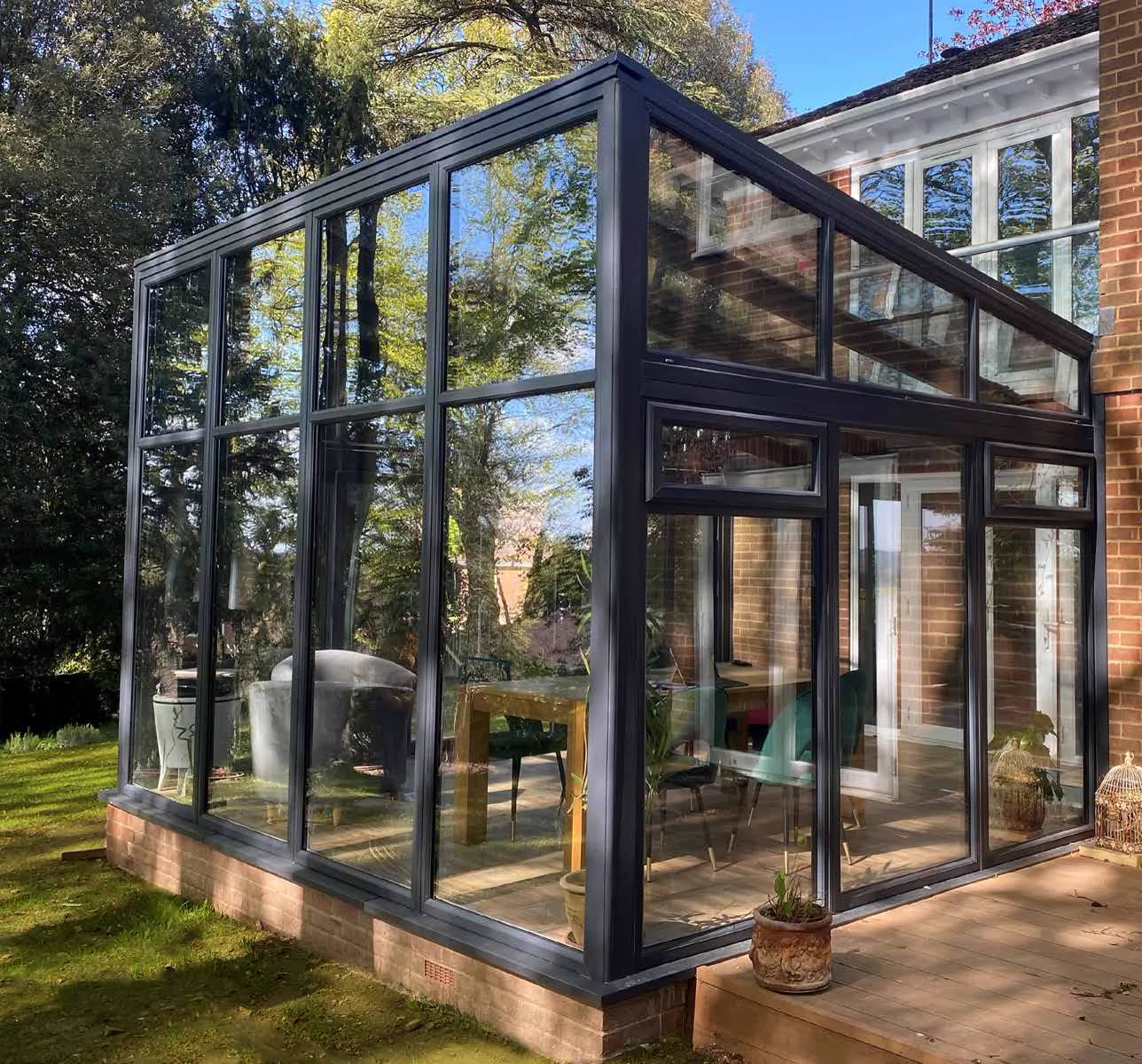 Dark-framed lean-to conservatory adjoining a brick home