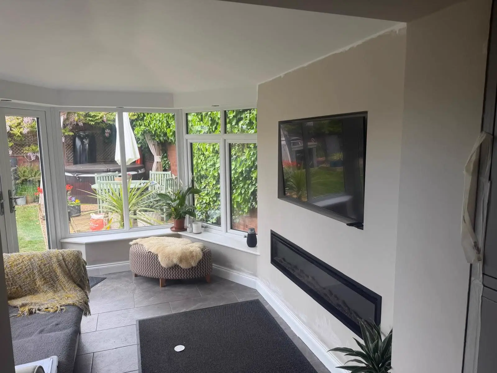 Conservatory seating area with white frames and a finished ceiling