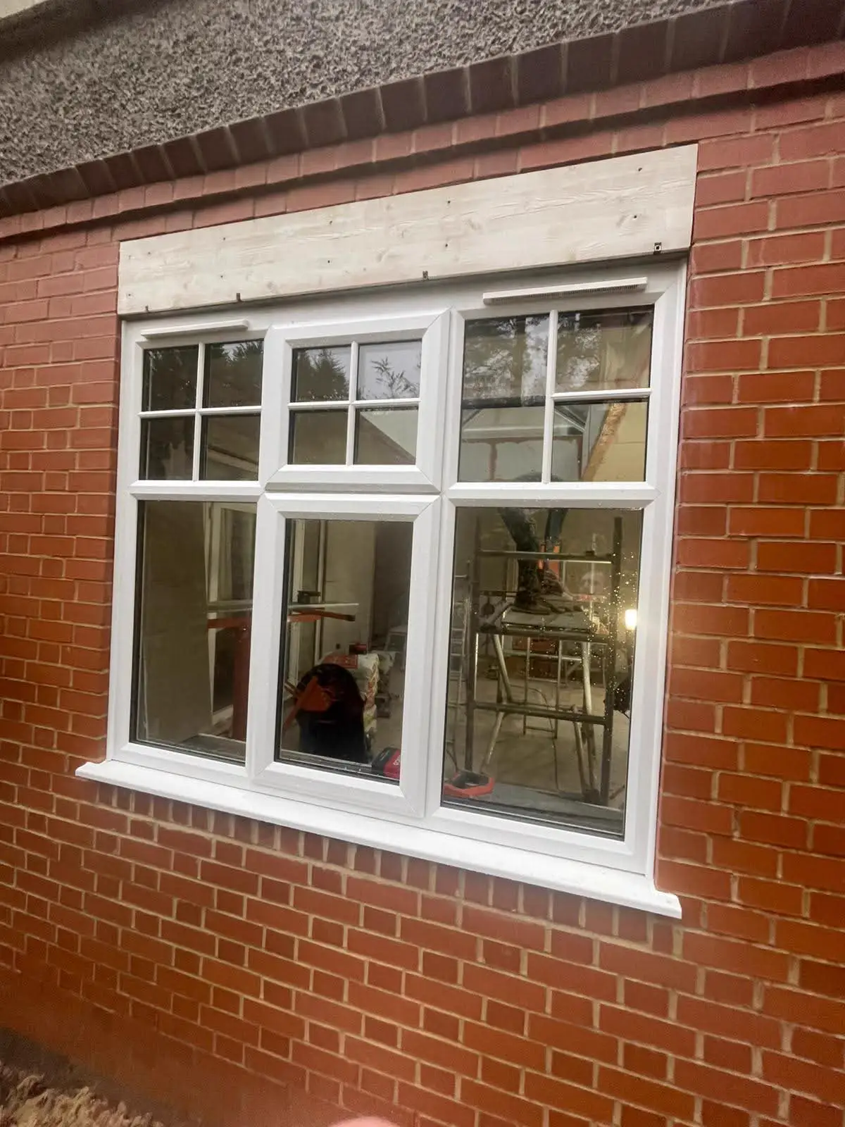 White-framed casement window in a brick wall